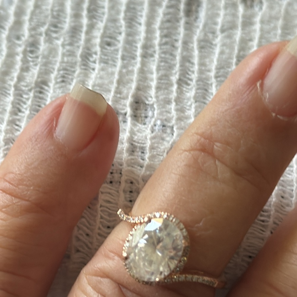 Beautiful oval moissanite in 14K rose gold setting, small diamonds surrounding